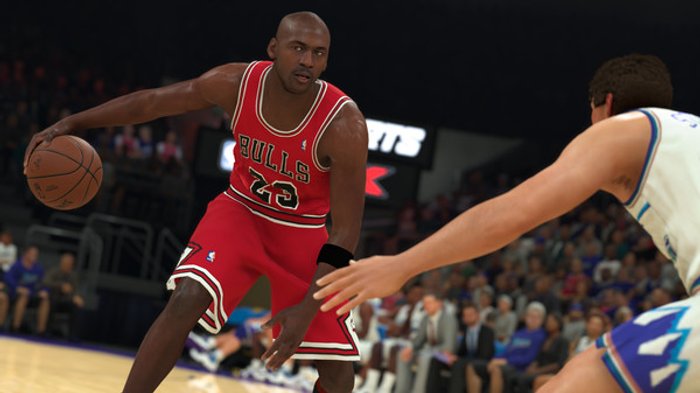 Screenshot z gry NBA 2K23 przedstawiający koszykarza w czerwonym uniformie w trakcie akcji na boisku